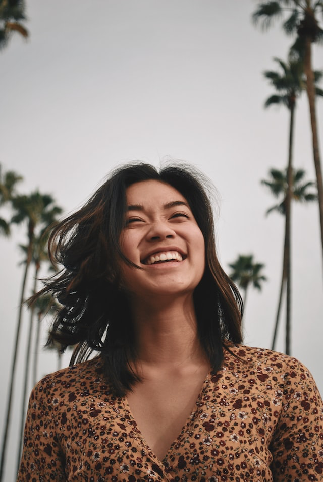 Girl smiling under palm trees